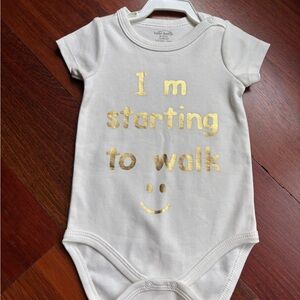 White Baby Onesie with Gold I’m starting to Walk Text